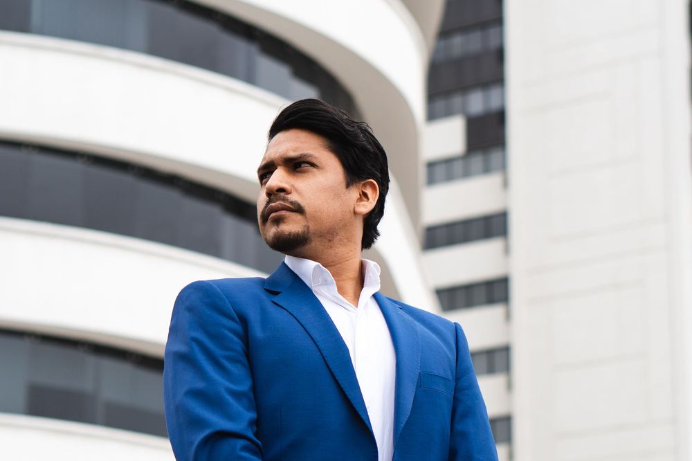 Business owner in a blue suit outside a modern office building