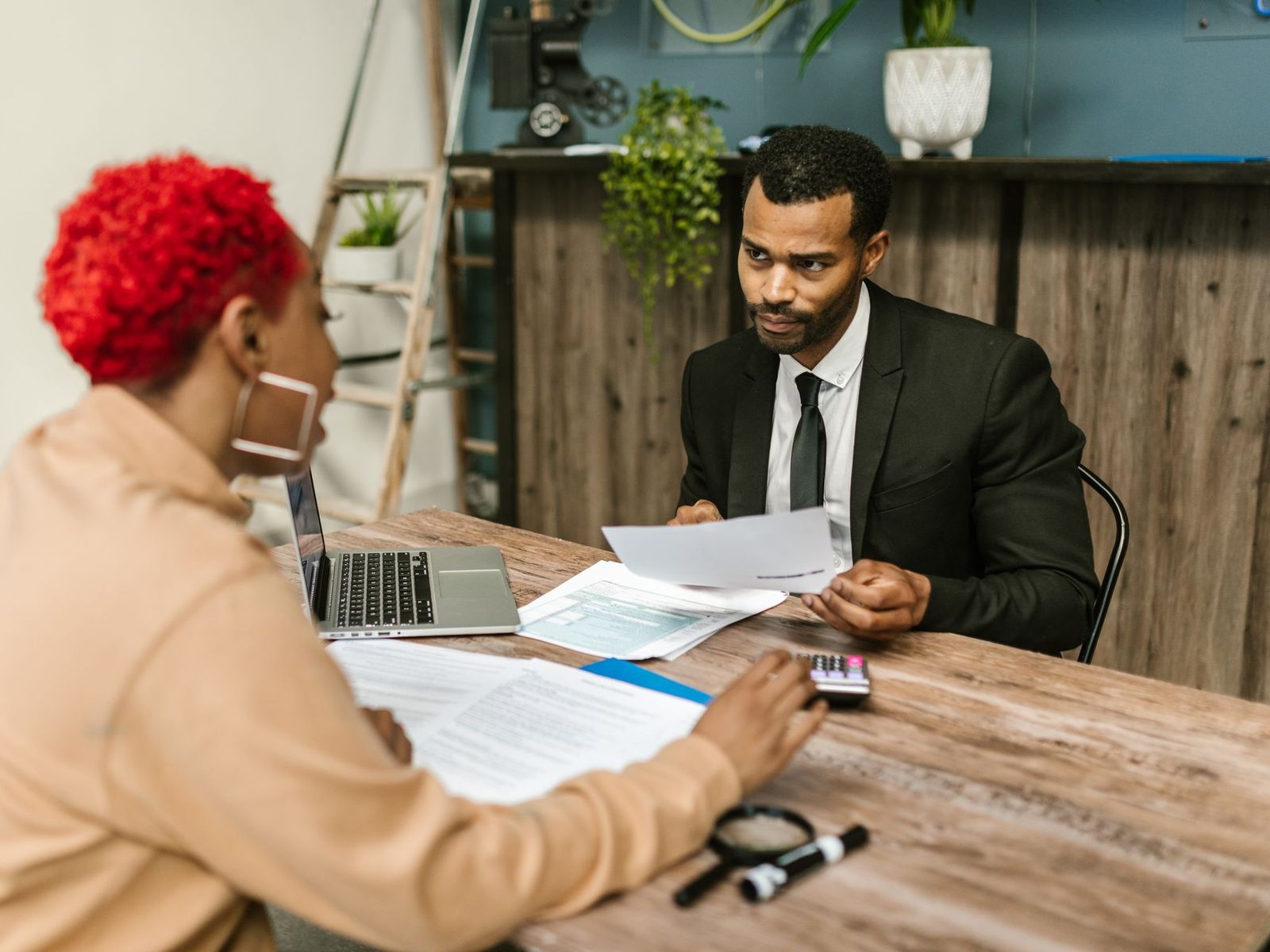 Two professionals reviewing documents together across a wooden desk