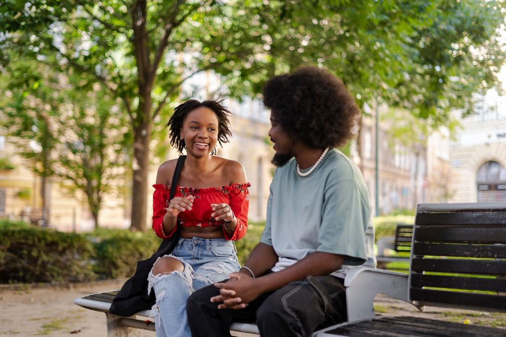 A couple talking together on a park bench
